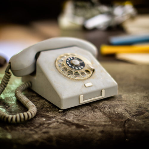 Vanha pöytäpuhelin, jossa on numerokiekko.