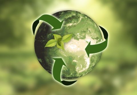 Tyylitelty maapallo, jonka ympärillä on kierrätykseen viittaavat vihreät nuolet.