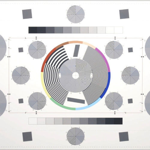 TV-ruudun virityskuvaan viittaavaa estetiikkaa ja cd-levyn näköisiä harmaita ympyröitä.
