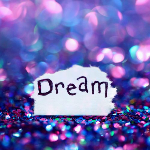 Glitter-kimalteen päällä on lappu, jossa lukee Dream eli unelma tai unelmoi.