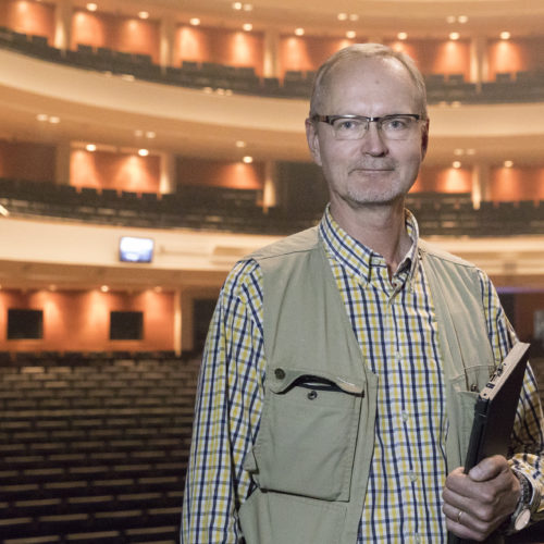 Suomen Kansallisopperan ja -baletin lavastamon osastopäällikkö ja ympäristöpäällikkö Tapio Säkkinen seisoo Oopperatalon päänäyttämön lavalla. Hänen takanaan näkyy tyhjä katsomo.
