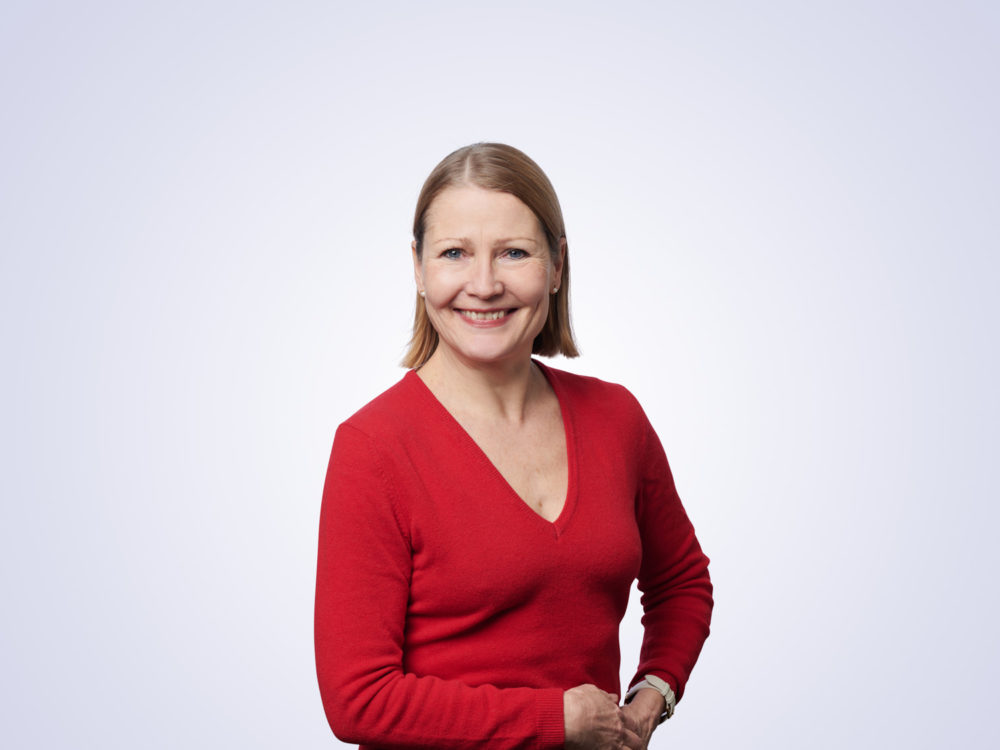 Taiteen edistämiskeskus Taiken johtaja Paula Tuovinen hymyilee punaisessa puserossaan.